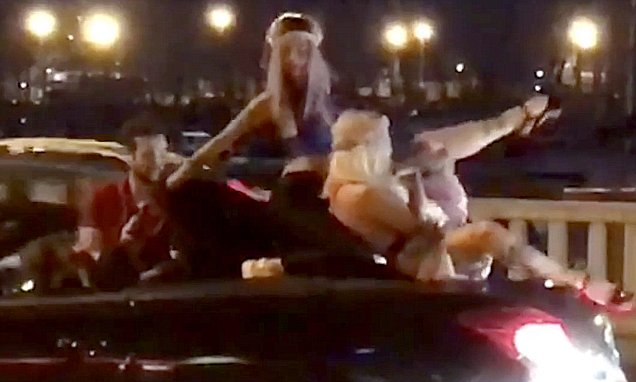 VIDEO/ Striptizëm mbi makinë në mes të rrugës, bjondet hutojnë kalimtarët