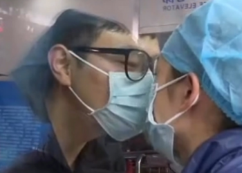 11 ditë të ndarë për shkak të koronavirusit, puthja e çiftit përmes xhamit bën xhiron e rrjetit (Video)