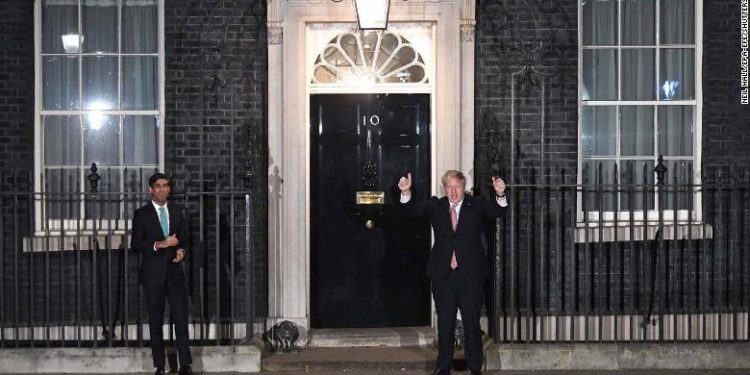 Mandatory Credit: Photo by NEIL HALL/EPA-EFE/Shutterstock (10594210cx)
Britain's Prime Minister Boris Johnson (R) and Chancellor of the Exchequer Rishi Sunak (L) clap outside the official residence at 10 Downing Street in London, Britain, 26 March 2020. Briton's are encouraged to clap for carers at 8pm local time to celebrate employees of the National Health Service (NHS). Britain's Prime Minister Boris Johnson has implemented social distancing measures banning social gatherings and groups of more than two people. People must stand more than two metres apart. Several European countries have closed borders, schools as well as public facilities, and have cancelled most major sports and entertainment events in order to prevent the spread of the SARS-CoV-2 coronavirus causing the Covid-19 disease.
Coronavirus in Britain, London, United Kingdom - 26 Mar 2020