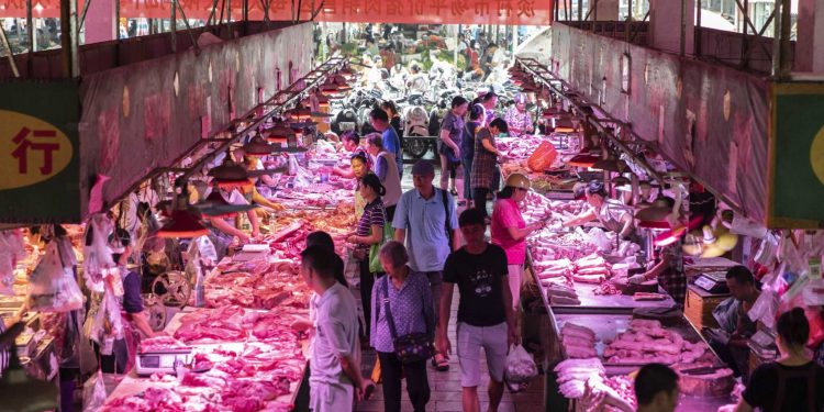 Customers walk past pork stalls at a market in Nanning, Chinga, on Sept. 17, 2019. MUST CREDIT: Bloomberg photo by Qilai Shen.