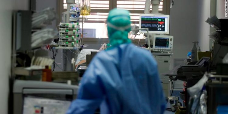 A doctor watches a coronavirus patient under treatment in the intensive care unit of the Brescia hospital, Italy, Monday, March 16, 2020. For most people, the new coronavirus causes only mild or moderate symptoms. For some, it can cause more severe illness, especially in older adults and people with existing health problems. (AP Photo/Luca Bruno)