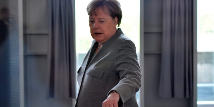 Mesazhi i koduar për kancelaren Merkel: Një gur varri i rrethuar nga trëndafila të kuq dhe qirinj para zyrës