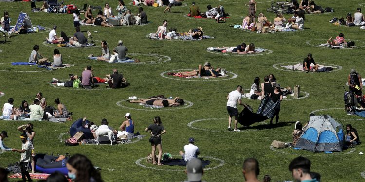 Visitors set up inside circles designed to help prevent the spread of the coronavirus by encouraging social distancing at Dolores Park in San Francisco, Sunday, May 24, 2020. (AP Photo/Jeff Chiu)