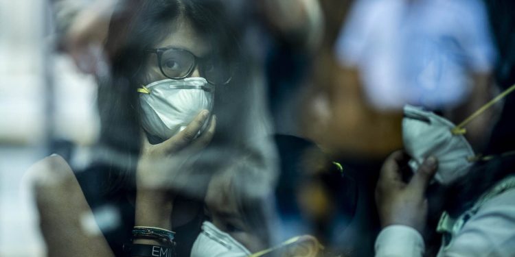 TOPSHOT - Passengers walk while wearing protective masks, as a preventive measure regarding the COVID-19 virus, at Jorge Chavez International Airport, in Lima on February 27, 2020. - So far, Peru has no record of the COVID-19 virus cases. (Photo by Ernesto BENAVIDES / AFP) (Photo by ERNESTO BENAVIDES/AFP via Getty Images)