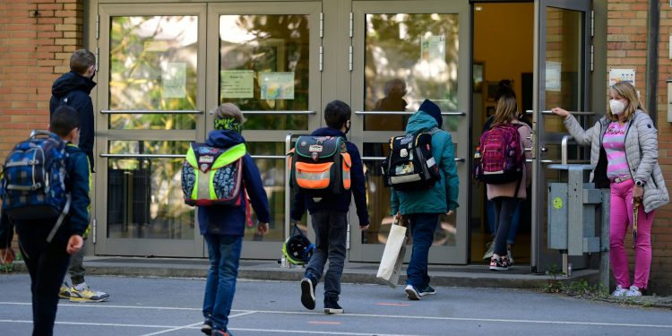 TOPSHOT - Children respect social distancing rules as they enter the Petri primary school in Dortmund, western Germany, on May 7, 2020, as the school reopens for some pupils following lockdown due to the new coronavirus Covid-19 pandemic. - The primary schools in the western federal state of North Rhine-Westphalia reopened as planned for fourth-graders. (Photo by Ina FASSBENDER / AFP) (Photo by INA FASSBENDER/AFP via Getty Images)