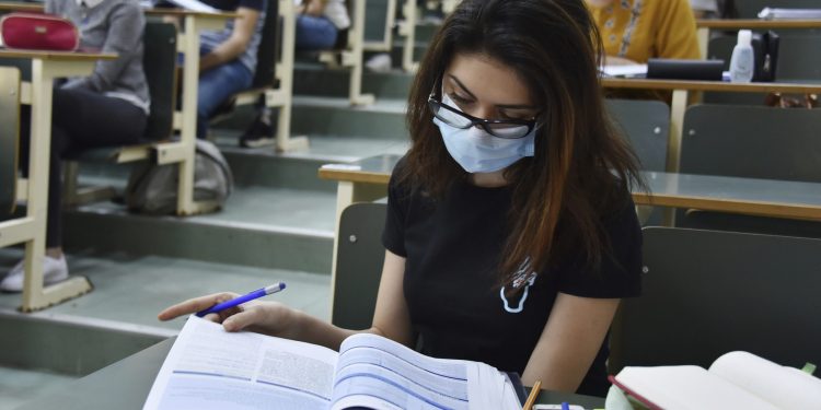 A medical student wearing a face mask as a preventive measure reads a books at the Faculty of Medicine. This recovery concerns six faculties of medicine, pharmacy and dentistry after the stabilization of the health situation in Tunisia announced by the Minister of Higher Education and Scientific Research Slim Choura. (Photo by Jdidi Wassim / SOPA Images/Sipa USA)(Sipa via AP Images)