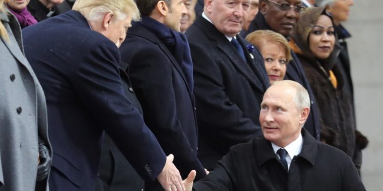 Russian President Vladimir Putin (R) shakes hands with US President Donald Trump as he arrives to attend a ceremony at the Arc de Triomphe in Paris on November 11, 2018 as part of commemorations marking the 100th anniversary of the 11 November 1918 armistice, ending World War I. (Photo by ludovic MARIN / POOL / AFP)