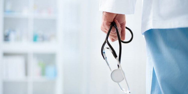 Doctor with stethoscope in a hospital, back view