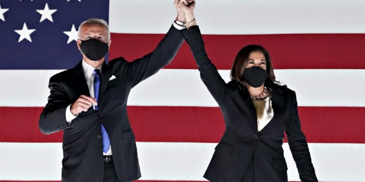 Former Vice President Joe Biden, Democratic presidential nominee, left, and Senator Kamala Harris, Democratic vice presidential nominee, wear protective masks while holding hands outside the Chase Center during the Democratic National Convention in Wilmington, Delaware, U.S., on Thursday, Aug. 20, 2020. Biden accepted the Democratic nomination to challenge President Donald Trump, urging Americans in a prime-time address to vote for new national leadership that will overcome deep U.S. political divisions. Photographer: Stefani Reynolds/Bloomberg via Getty Images