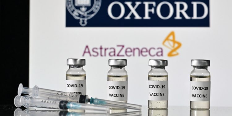 An illustration picture shows vials with Covid-19 Vaccine stickers attached and syringes, with the logo of the University of Oxford and its partner British pharmaceutical company AstraZeneca, on November 17, 2020. (Photo by JUSTIN TALLIS / AFP)