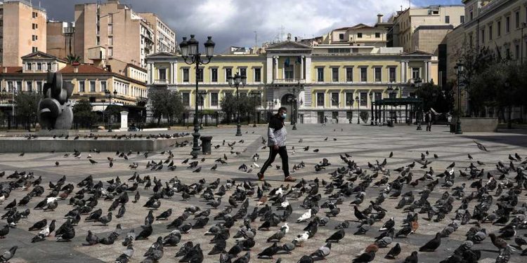 A man wearing a protective face mask makes his way on the empty Kotzia square, during the coronavirus disease (COVID-19) outbreak, in Athens, Greece, April 7, 2020. REUTERS/Alkis Konstantinidis