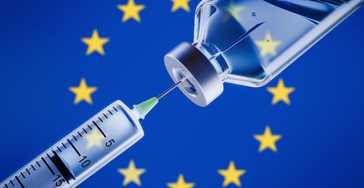 Closeup of a syringe and vaccine in front of European flag background