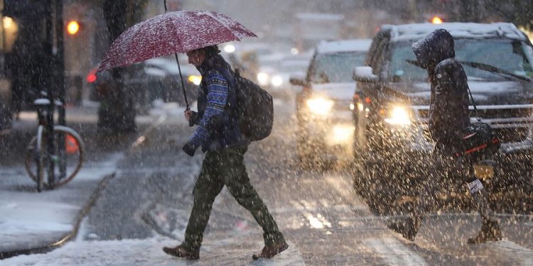 NEW YORK, NY - NOVEMBER 15:  Pedestrians walk through a wintery mix of snow and ice in Manhattan on November 15, 2018 in New York City. New York experienced its first snowfall of the season on Thursday with expectations of over an inch of snow to fall on the area.  (Photo by Spencer Platt/Getty Images)