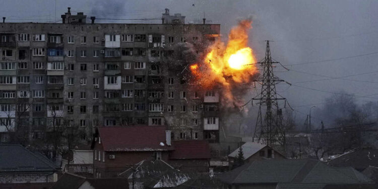 An explosion is seen in an apartment building after Russian's army tank fires in Mariupol, Ukraine, Friday, March 11, 2022. (AP Photo/Evgeniy Maloletka)