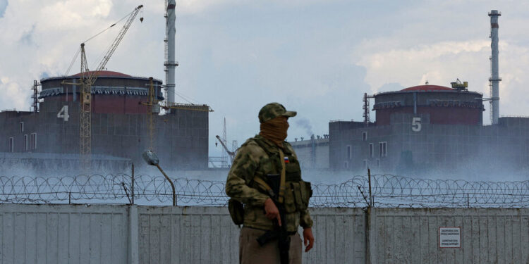 FILE PHOTO: A serviceman with a Russian flag on his uniform stands guard near the Zaporizhzhia Nuclear Power Plant in the course of Ukraine-Russia conflict outside the Russian-controlled city of Enerhodar in the Zaporizhzhia region, Ukraine August 4, 2022. REUTERS/Alexander Ermochenko/File Photo