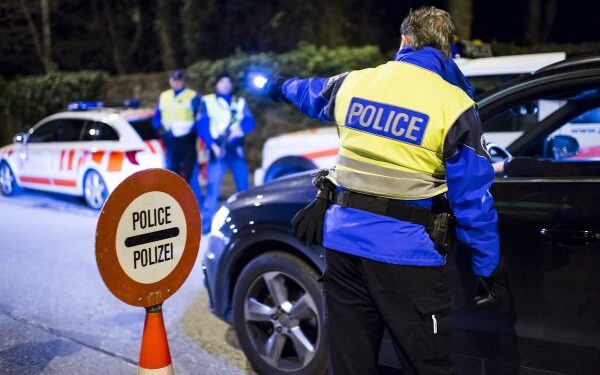 Des policiers controlent des automobilistes lors d'un controle de circulation comprenant la police et la gendarmerie genevoise et vaudoise ainsi que les gardes frontieres ce mardi soir 23 decembre 2014 sur la route Suisse entre Versoix dans le canton de Geneve et Mies dans le canton de Vaud. (KEYSTONE/Jean-Christophe Bott)