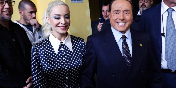This photo obtained from Italian news agency Ansa shows former Italian Prime Minister and leader of the Italian right-wing party "Forza Italia" (FI), Silvio Berlusconi, and his partner Marta Fascina arrive to cast their vote on September 25, 2022 at a polling station in Milan, as as the country is voting for the legislative election. - Italians on September 25 were voting in a pivotal legislative election, with the far right expected to lead the eurozone's third-largest economy for the first time since World War II. (Photo by MATTEO BAZZI / ANSA / AFP) / Italy OUT