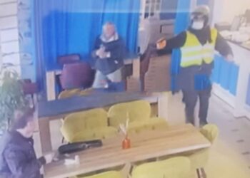 FOTO/ Momenti i ekzekutimit: Biznesmeni i ulur në tavolinë, autori me skafandër e jelek i drejton armën dhe qëllon