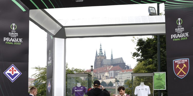 Soccer Football - Europa Conference League - Fans gather in Prague ahead of the Europa Conference League Final - Prague, Czech Republic - June 6, 2023 A West Ham United fan poses for a photograph next to the Europa Conference League trophy and jerseys REUTERS/David W Cerny