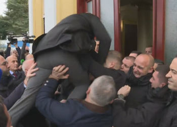 VIDEO / “Më ngre një çik aman”, Dash Sula si Selam Musai, hidhet mbi gardistët për t’u futur në sallë
