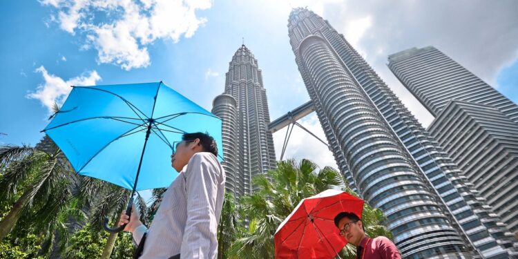 People protecting themselves from the scorching hot sun with umbrella infront of KLCC. Tem­per­a­tures con­tin­ued to soar through­out the coun­try as the num­ber of ar­eas on heat­wave alert dou­bled to 10 com­pared with two weeks ago. RAJA FAISAL HISHAN/The Star