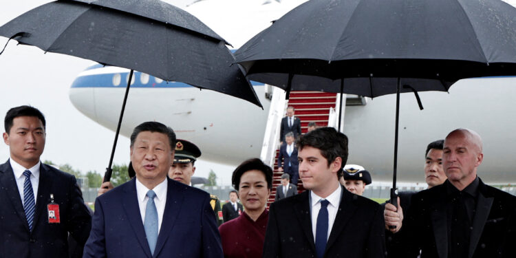 France's Prime Minister Gabriel Attal, China's President Xi Jinping and his wife Peng Liyuan walk under umbrellas upon their arrival for an official two-day state visit, at Orly airport, south of Paris on May 5, 2024. Chinese President Xi Jinping arrived in France on May 5, 2024, for a state visit hosted by Emmanuel Macron where the French leader will seek to push his counterpart on issues ranging from Ukraine to trade.     STEPHANE DE SAKUTIN/Pool via REUTERS