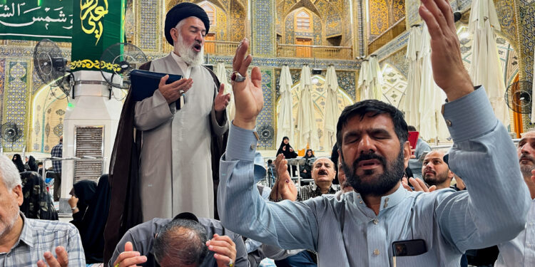 Iranian Shi'ite pilgrims pray for Iran's President Ebrahim Raisi, following the crash of a helicopter carrying him, at the Imam Ali shrine in the holy city of Najaf, Iraq May 19, 2024. REUTERS/Alaa Al-Marjani