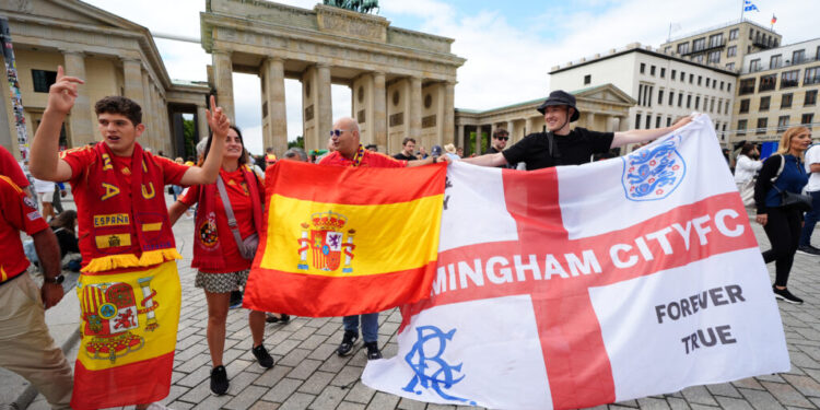 Spain and England fans hold up their national flags as they gather next to the Brandenburg Gate in Berlin, Germany, ahead of the UEFA Euro 2024 final between Spain and England on Sunday. Picture date: Saturday July 13, 2024. PA Photo. See PA Story SOCCER Euro 2024. Photo credit should read: Andrew Milligan/PA Wire. RESTRICTIONS: Use subject to restrictions. Editorial use only, no commercial use without prior consent from rights holder.