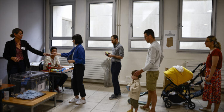 People queue to vote in the second round of the early French parliamentary elections, at a polling station in Paris, France, July 7, 2024. REUTERS/Yara Nardi