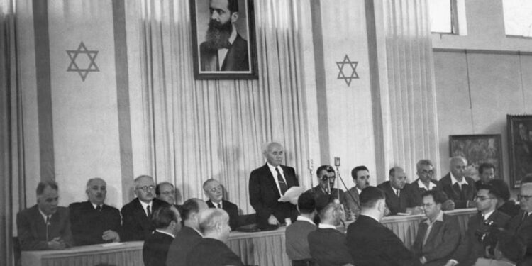 David Ben Gurion duke mbajtur fjalimin mbi shpalljen e Shtetit të Izraelit, 14 maj 1948 (sipër tij, një portret i Herzl)