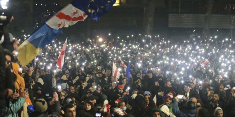 Demonstrators stand in front of police during a rally outside the parliament's building to protest the government's decision to suspend negotiations on joining the European Union for four years in Tbilisi, Georgia, on Saturday, Nov. 30, 2024. (AP Photo/Zurab Tsertsvadze)