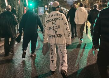 FOTOLAJM/ “Vëllazën, demokracia në rrezik! Ta shpëtojmë!”, protestuesi mbush veshjen e bardhë me mbishkrime