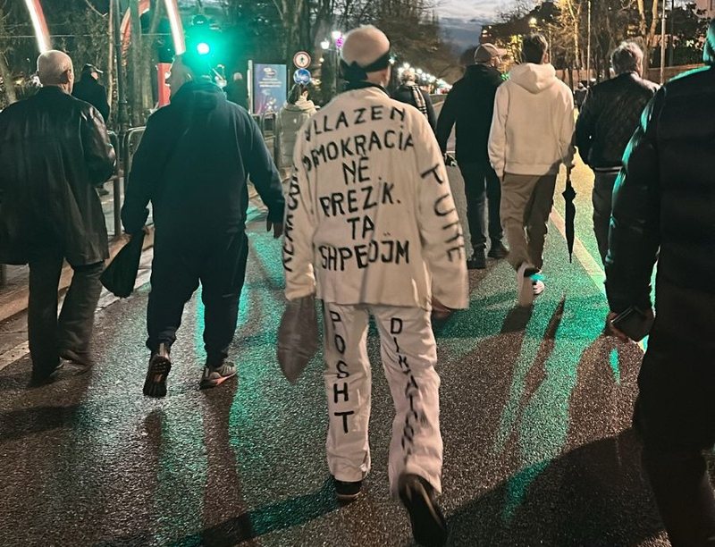 FOTOLAJM   Vëllazën  demokracia në rrezik  Ta shpëtojmë    protestuesi mbush veshjen e bardhë me mbishkrime