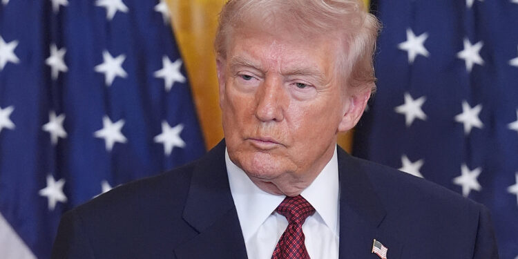 President Donald Trump listens as Kayla Blackford, a heavy equipment operator at Bear Run Mine near Carlisle, Ind., speaks during an event on coal power in the East Room of the White House, Wednesday, Feb. 11, 2026, in Washington. (AP Photo/Evan Vucci)