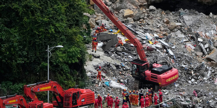 Rescuers use a heavy duty machine to clear the rubble to search for trapped victims at the scene of a landslide in Pengshui County in southwestern China's Chongqing on Saturday, July 18, 2026. (AP Photo/Andy Wong)