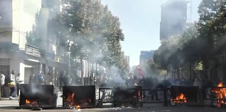 Dita e pestë e protestës  rruga bllokohet me koshat e mbeturinave që u vihet flaka  Të rinjtë sulmojnë me gurë  Policia i zmbraps me gaz e ujë
